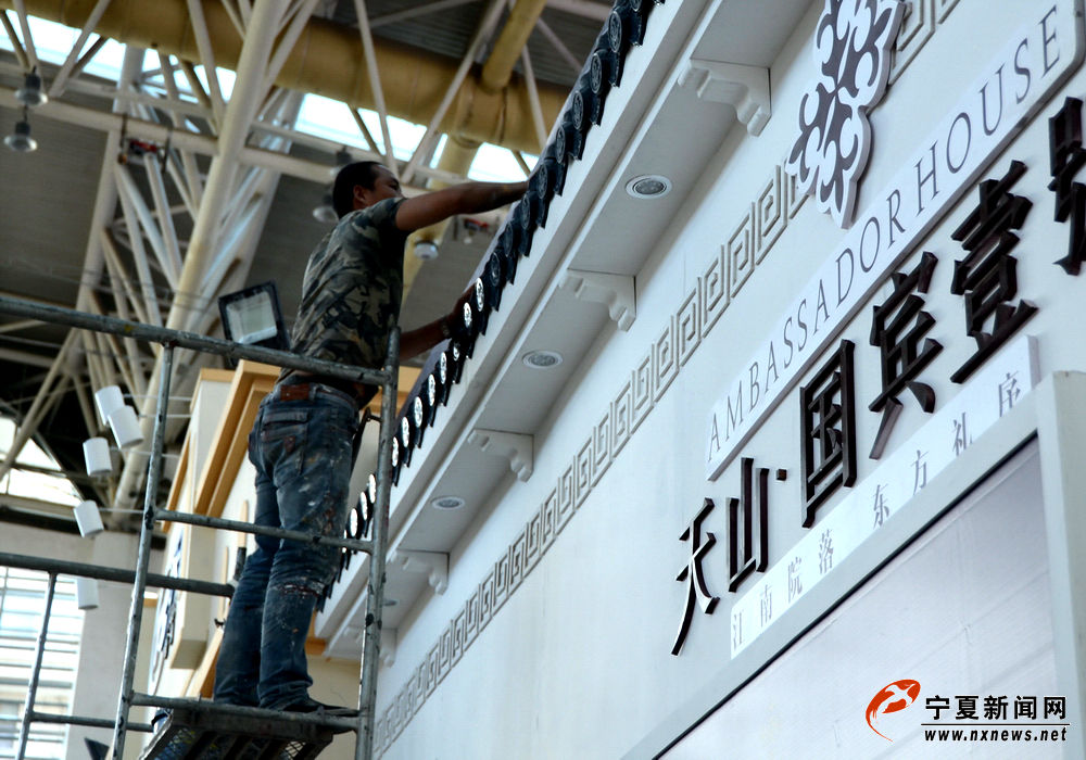 4月27日，在本次展会开幕前，房地产参展商的工作人员正在银川国际会展中心精心布置楼盘展台。