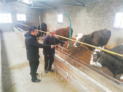 <p>　　李长银（左一）入户走访村民，鼓励扩大养牛规模。　　　　　（图片由受访者提供）</p>