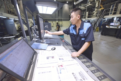 <p>　　工人认真比对印刷的报纸，及时通过电脑进行调色。本报记者　党硕　摄</p>