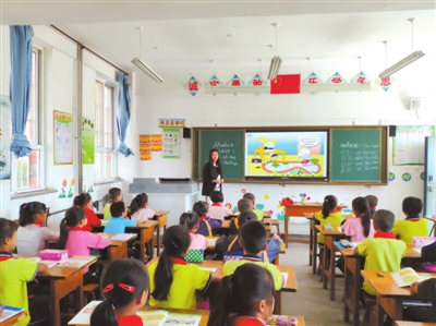 平罗县红瑞燕宝小学老师使用多媒体触摸一体机给学生上英语课。