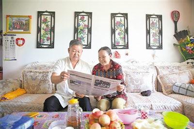 <p>　　纳永祥（左）为妻子金学花读报。</p>