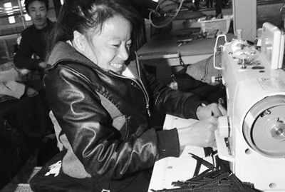 残疾女工杨继兰在吴忠市红寺堡弘德工业园区爱德制衣厂车间操作缝纫机。  资料图片
