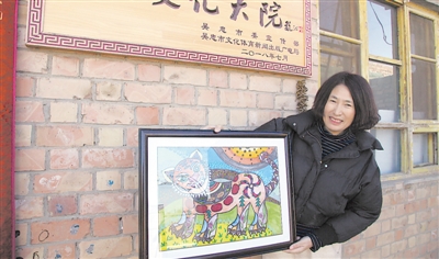 <p>　　杨玉英展示她创作的绘画作品。</p>