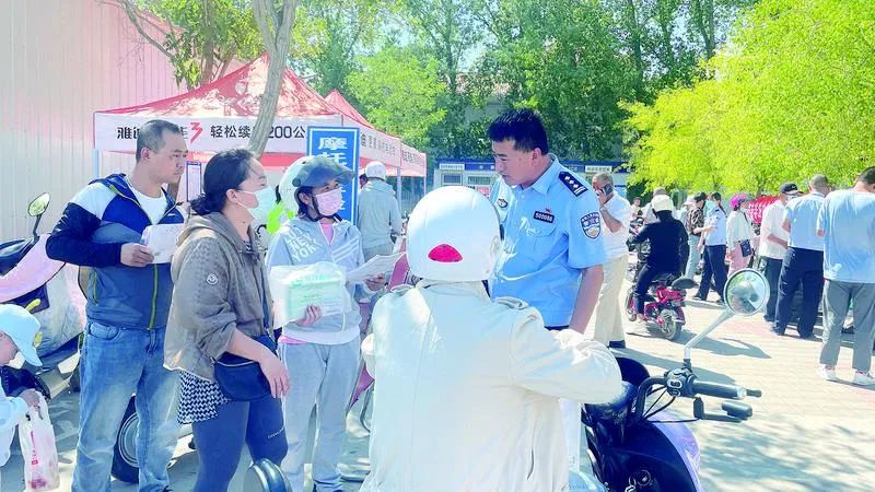 民警向市民讲解电动自行车登记挂牌流程.jpg