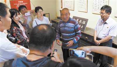 <p>　　乔德雄（右二）为记者讲述毛泽东夜宿乔家渠的故事。								　　　　　　相关报道见三版</p>