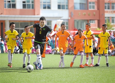 <p>　　央视少儿频道主持人绿泡泡（左二）与孩子们切磋球技。　</p><p>　　本报记者　李涛　王洋　摄</p>