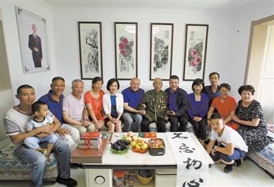 <p>　　小分队成员和谭德本老人（右七）及家人合影。　　　　　本报记者　李涛　王洋　摄</p>