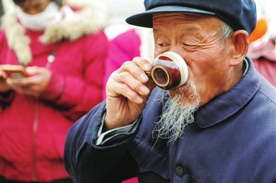     参赛选手品尝自己刚煮好的罐罐茶。