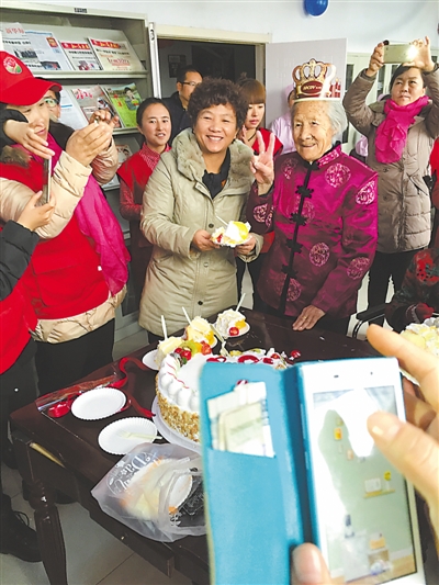 <p>　　何宁红（端蛋糕者）和养老公寓工作人员为老人过生日。</p><p>　　（图片由受访者提供）　</p>