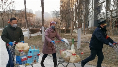 <p>　　李红彩（中）和同事一起为居家医学观察居民送生活物品。</p>