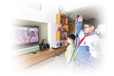 <p>2月17日，银川市兴庆区第二十三小学五年级六班的李厚泽与弟弟在家中通过电视收看《开学第一课》。　　　本报记者　李涛　摄</p>