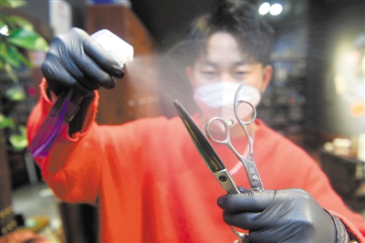 <p>　　发型师小龙对自己的理发工具仔细消毒。</p>