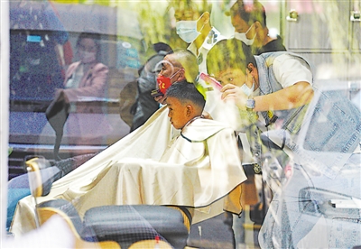 <p>　　美发店里的理发师为顾客精心梳理着心仪的发型。</p>