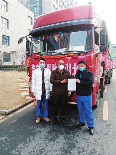 杨荣荣（中）拿着武汉大学人民医院东院给他的感谢信，与两位接待他的博士合影。

    杨荣荣供图