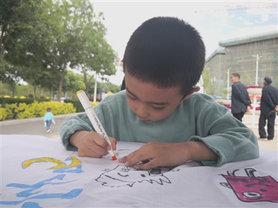 在彭阳县司法局组织的游园活动中，一名儿童认真绘制“心中的民法典”。