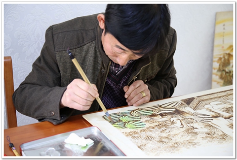 倪建成烙铁画创作中.jpg