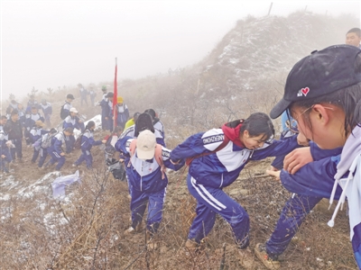 <p>　　　　雨雪交加，学生们携手前行。　　　　本报记者　王玉平　摄</p>