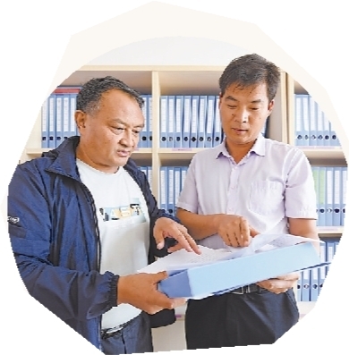 <p>　　扶贫工作队队长陈华平（左）与同事核对贫困户资料。</p>