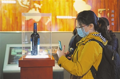 <p>　　参观者用手机拍下酒庄的“明星产品”。　　　　　　　　　本报记者　张唯　摄</p>