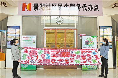 <p>　　→　李左安（右）在制作《一起向未来》剪纸作品。</p><p>　　本报记者　杨超　摄</p>