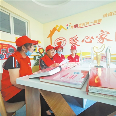 <p>　　6月8日，王兰花（左二）与志愿者交流工作心得。　本报记者　蒲利宏　摄　　</p>