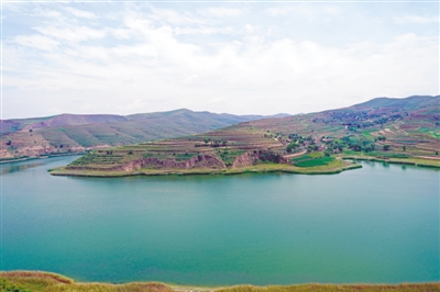 <p>　　6月22日，距离西吉县城约38公里处的震湖，潋滟湖水与层层梯田构成一幅山水画。</p>
