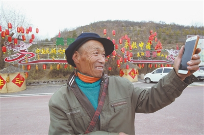 <p>　　　　村民徐国礼通过手机视频向家人分享龙王坝村的美景。</p>