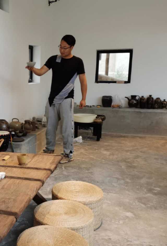 李海生展示西夏陶瓷体验店客人做的陶艺品。1.jpg