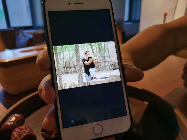 李海生展示手机里他和小游客的互动照片。3.jpg