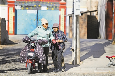 <p>　　11月25日，新堡镇创业村帮办员康静（左）走街串巷，上门服务群众。　　　　　　　　　　　　　　　　　　　本报记者　马楠　摄</p>
