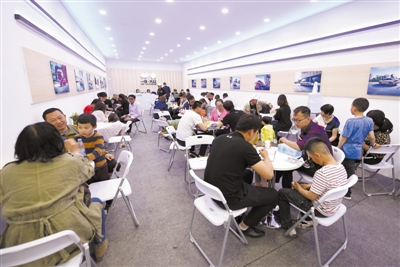 <p>　　　　汽车销售人员与顾客交流洽谈。本报记者　党硕　摄</p>