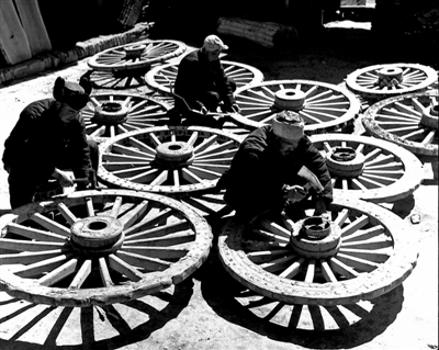 <p>　　1959年3月，固原县城郊人民公社农具厂的工人在赶修大车，支援春耕生产。　　　　　　　　　　朱康洛　摄</p>