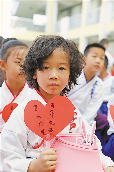 一年级学生拿着手工制作的卡片庆祝建党100周年