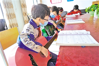 <p>　　孩子们在认真弹吉他。</p>