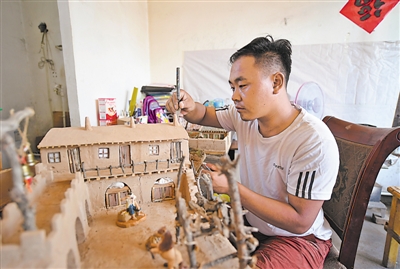 <p>　　陈科军正在给泥塑模型的屋顶安装瓦片。</p>
