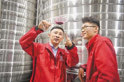 <p>　　杜俊琼（左）和工程师一起研究讨论今年原浆葡萄酒的成色与品质。</p>