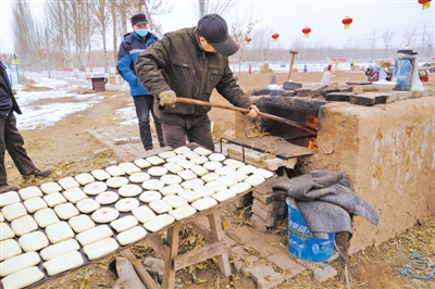<p>　　何其江用“土棚棚”烤制特色面点。</p>