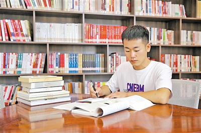 王建明在图书馆埋头苦读，备战硕士研究生考试。