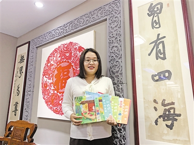<p>　　李剑展示《伏奶奶教你学剪纸》教材。</p>