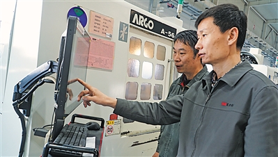 <p>　　李军（前）询问工人工作情况。</p>