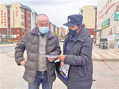 吴忠市公安局利通区分局民警走上街头，向老年人发放防范养老诈骗宣传单。