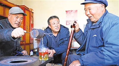 张易镇张易村党支部书记张金河（中）上门了解村民治疗情况。
