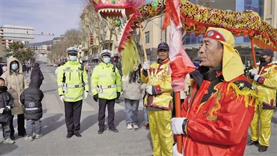 2月12日13时许，西吉县社火巡游展演活动正在进行，西吉县公安局交警大队出动警力80余人次，设置执勤点59处，及时疏导群众、引导车辆，维护道路交通秩序及现场秩序。    本报记者 刘炳宇 摄