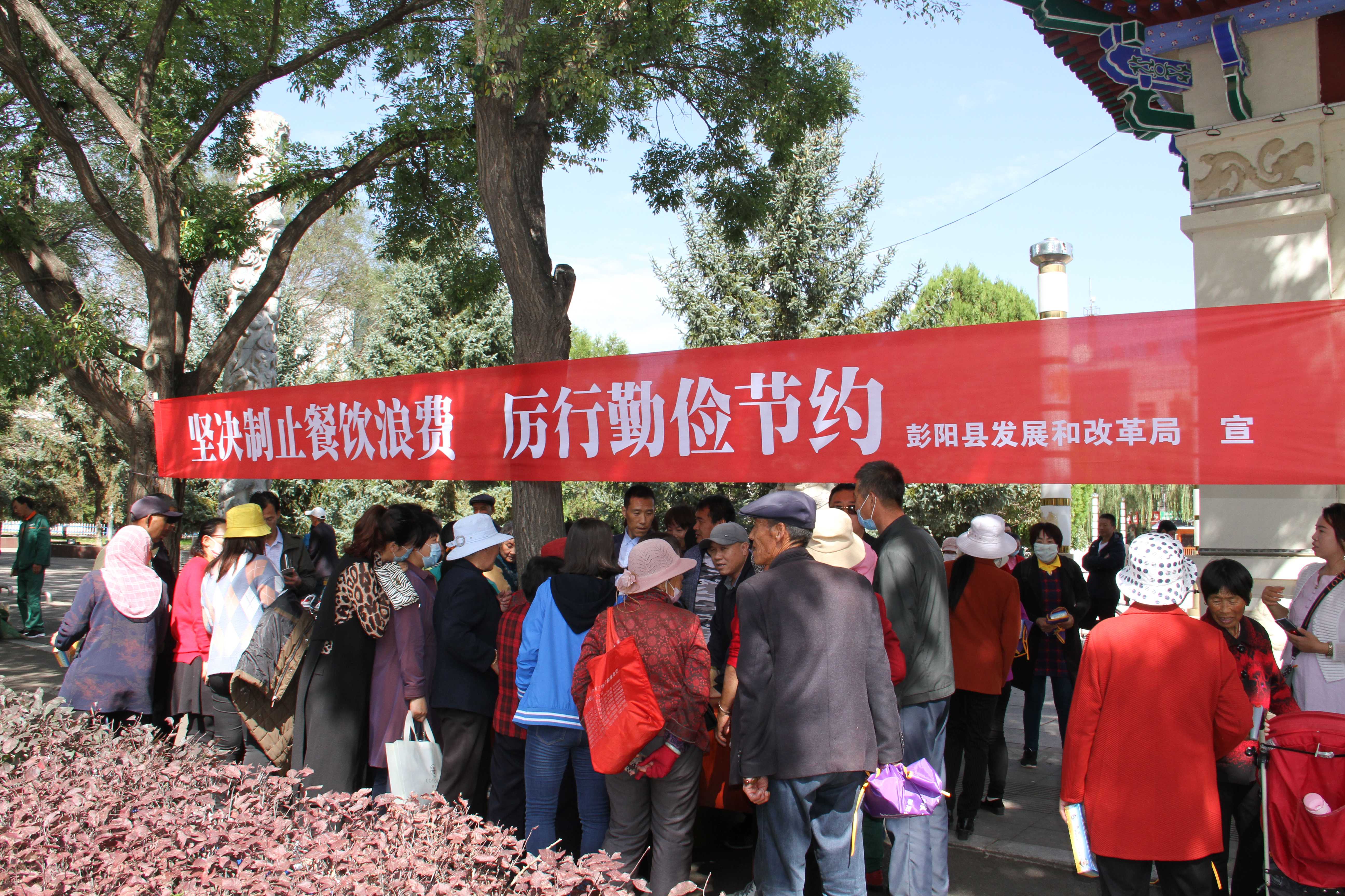 字样的横幅,工作人员向广大人民群众发放《节约粮食杜绝浪费倡议书》