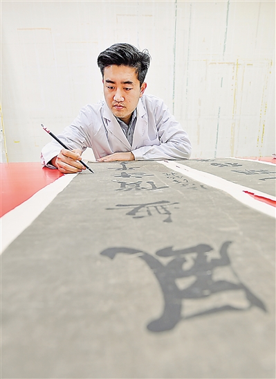     书画修复师陈志炜为宁夏博物馆馆藏书法作品全色。全色之前，这副对联已耗时两个月，经历过揭命纸、引局、洗画等十几道工序，全色是最关键一步。