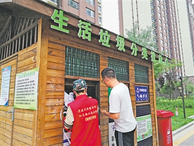 <p>　　志愿者引导居民分类投放垃圾。</p>