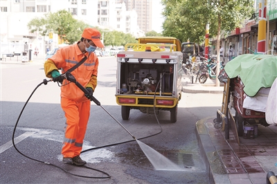     环卫工人孙军旗正在清洗路面。
