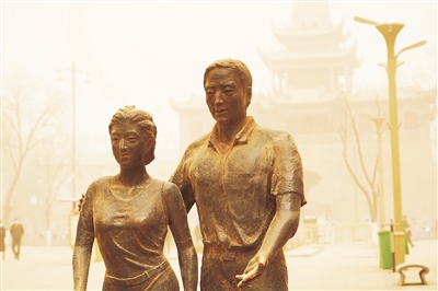     3月15日，银川市兴庆区鼓楼步行街上的一对雕塑上落满沙尘。
