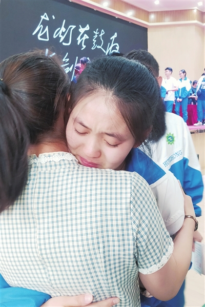老师给孩子一个鼓励的拥抱，孩子们依依不舍，含泪跟老师说再见！  @梅千雪摄