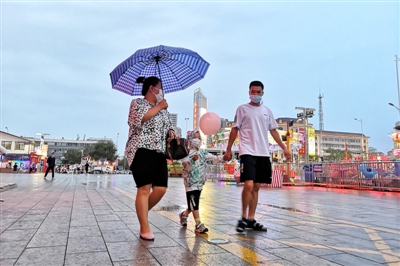 8月18日，在银川市西夏区宁阳广场，市民雨中漫步。当日，一场秋雨让市民感到些许秋凉。　　　　　　　　　　　　　　　　　　　　　　　本报记者    季正    摄